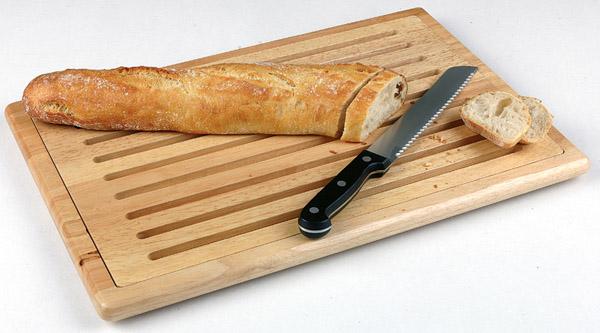Brot, Brotmesser, Holzbrett mit Rillen.