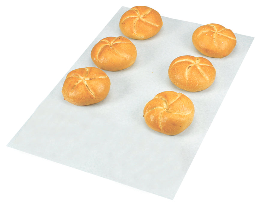 Sechs Brötchen auf Backpapier.