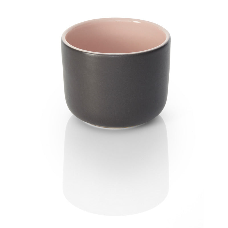 Schwarze Tasse mit rosa Innenfarbe.