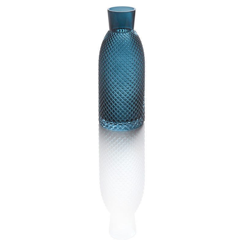 Blaues Glasgefäß auf reflektierender Oberfläche.