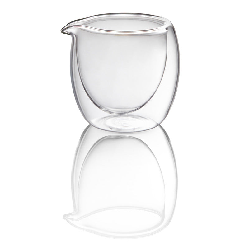 Transparente Kanne auf reflektierender Oberfläche.
