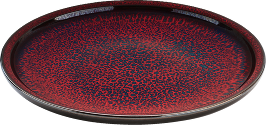 Roter Teller mit schwarzem Muster.