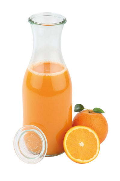 Karaffe mit Orangensaft und Orange.