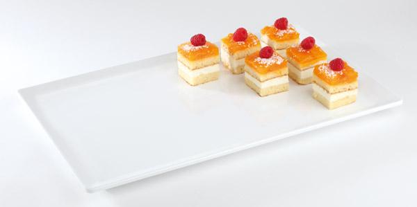 Kuchenstücke auf weißem Tablett.