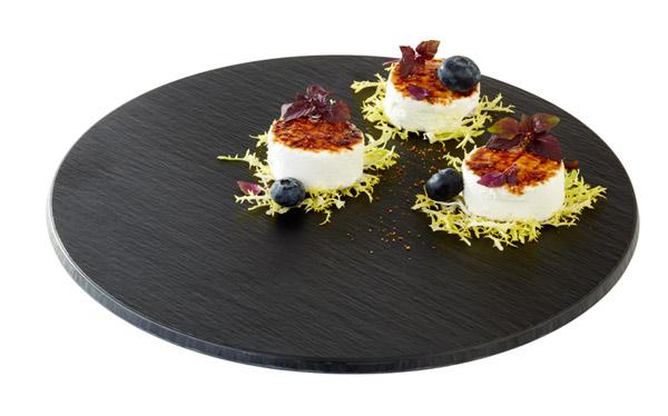 Drei Desserts auf schwarzem Teller.