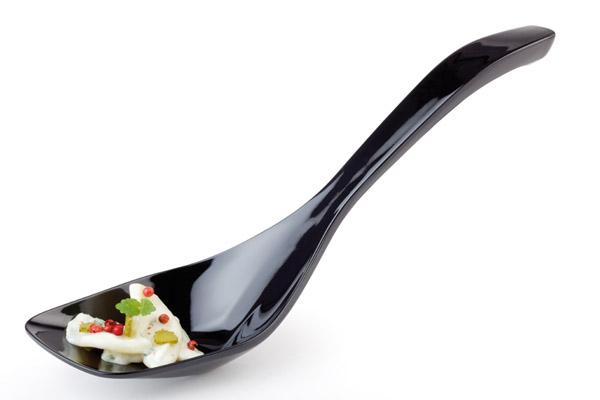 Schwarzer Löffel mit Vorspeise.