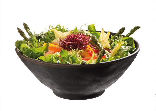 Salat in schwarzer Schüssel angerichtet.