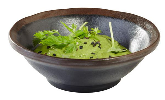 Schwarze Schale mit grüner Creme.