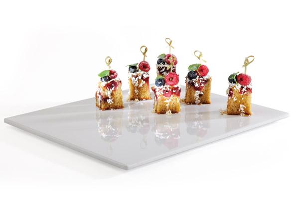 Kleine Kuchenstücke mit Beeren-Dekoration.