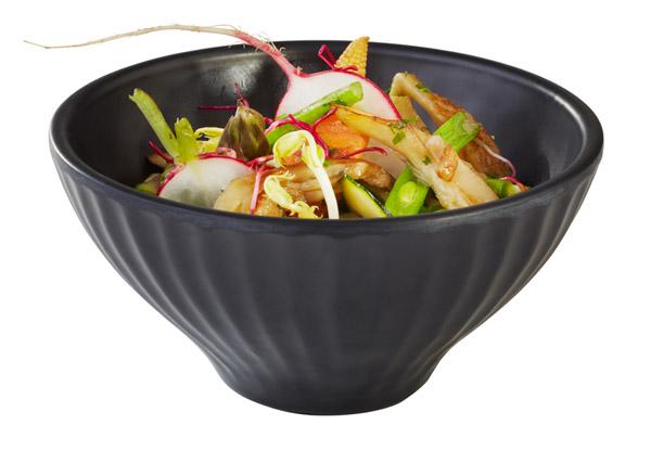 Schwarze Schüssel mit Gemüsegericht.