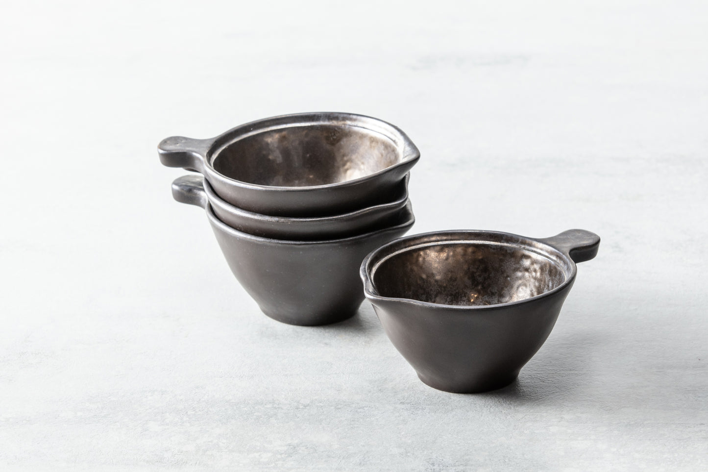 Drei gestapelte schwarze Schalen.