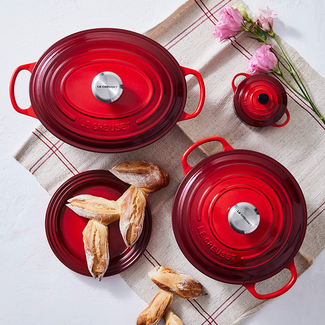 Rote Töpfe und Teller mit Baguette.