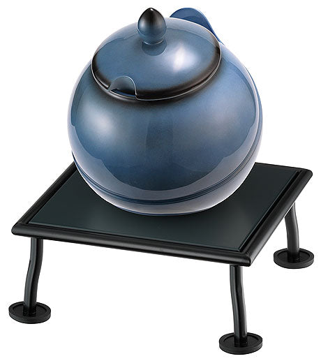 Blauer Topf auf schwarzem Tisch.