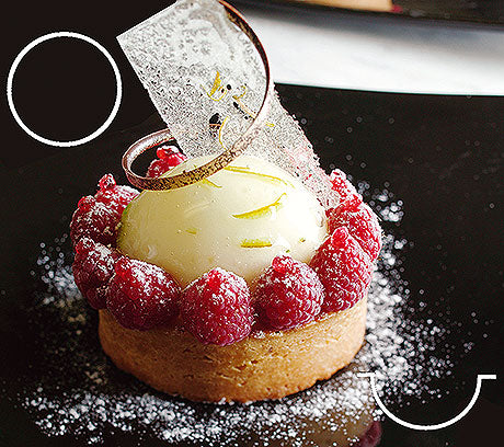 Dessert mit Himbeeren und Dekoration.