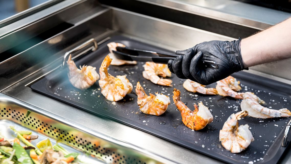 Garnelen werden auf Grillplatte zubereitet.