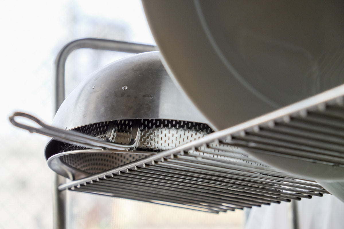 Pfanne und Teller auf Abtropfgestell.