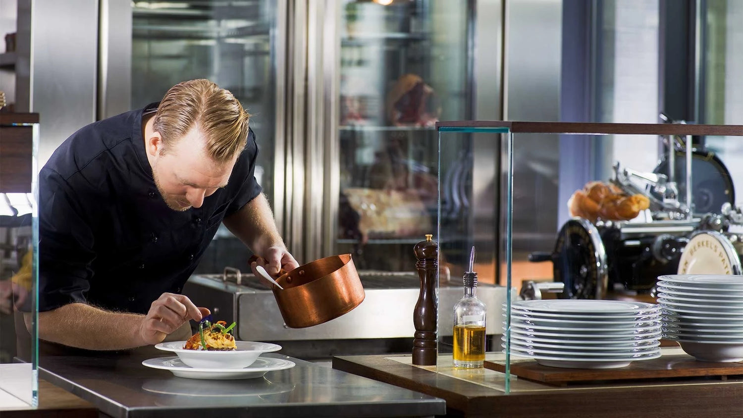 Koch richtet Teller in Restaurantküche an.