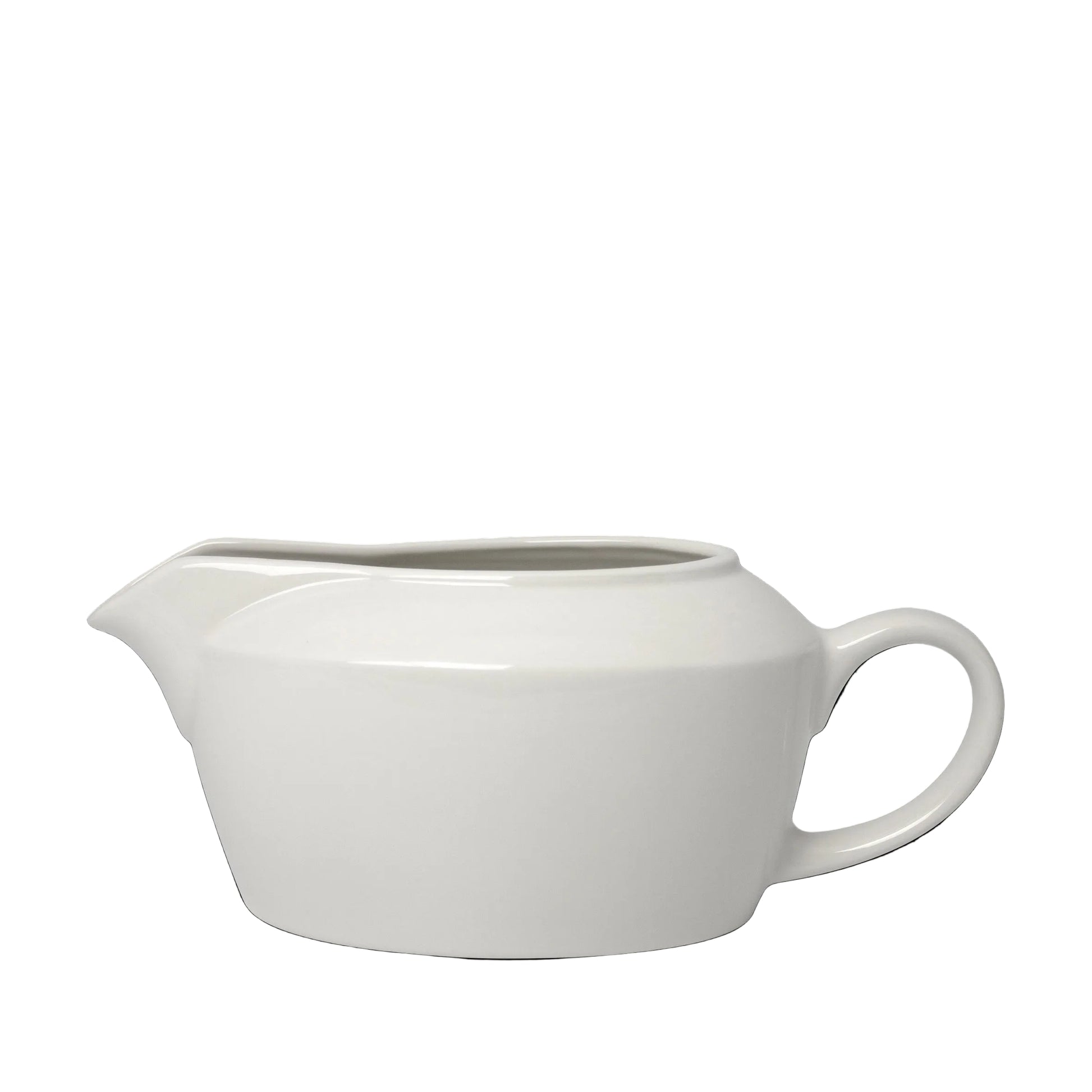 Weiße Porzellankanne vor schwarzem Hintergrund.
