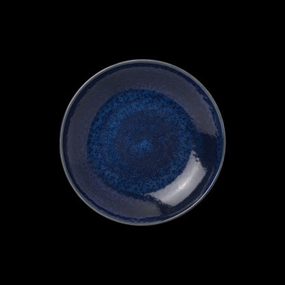 Blauer Teller auf schwarzem Hintergrund.