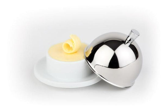 Butter mit Metallglocke auf Teller.