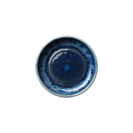 Blauer Keramikteller auf weißem Hintergrund.