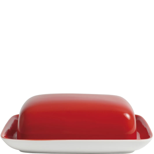 Rote Butterdose auf weißem Teller.