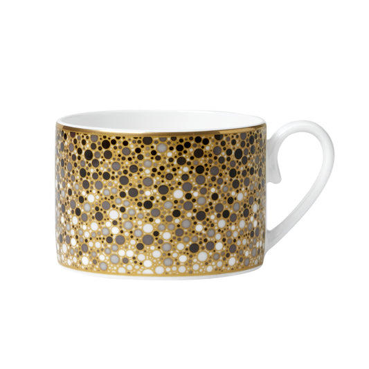 Tasse mit gold-schwarzem Punktmuster.