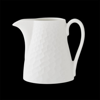 Weiße Porzellankanne mit Struktur.