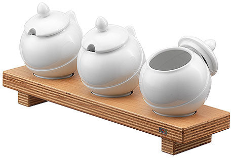 Drei weiße Porzellangefäße auf Holzständer.