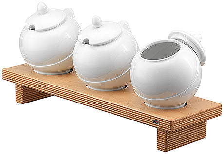 Drei weiße Keramikbehälter auf Holz.