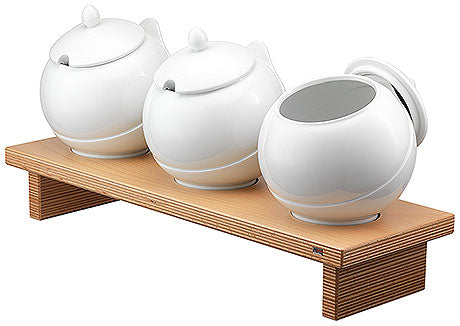 Drei weiße Gefäße auf Holzständer.