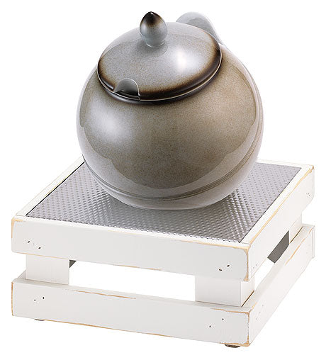 Suppentopf auf weißem Podest.