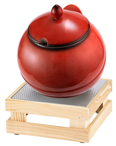 Roter Suppentopf auf Holzständer.