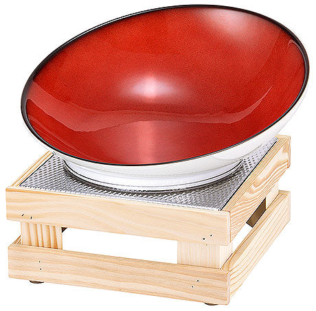 Rote Schale auf Holzständer.