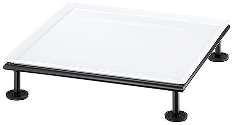 Erhöhte weiße Servierplatte aufgeständert.