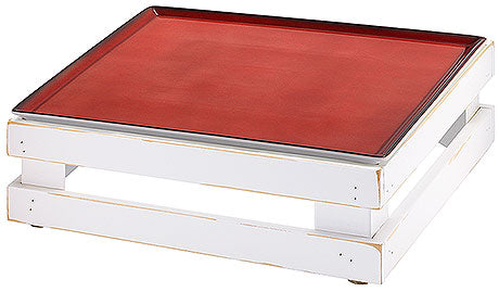 Rotes Tablett auf weißem Podest.